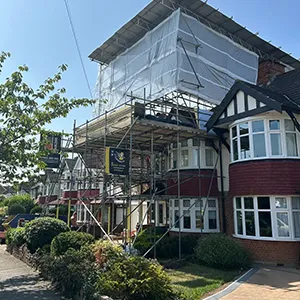 A house under construction with scaffolding on the roof.