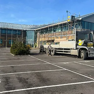 A truck parked in a parking lot next to a building.